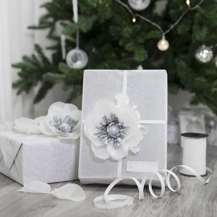 Silkkipaperikukalla koristeltu lahjapaketti