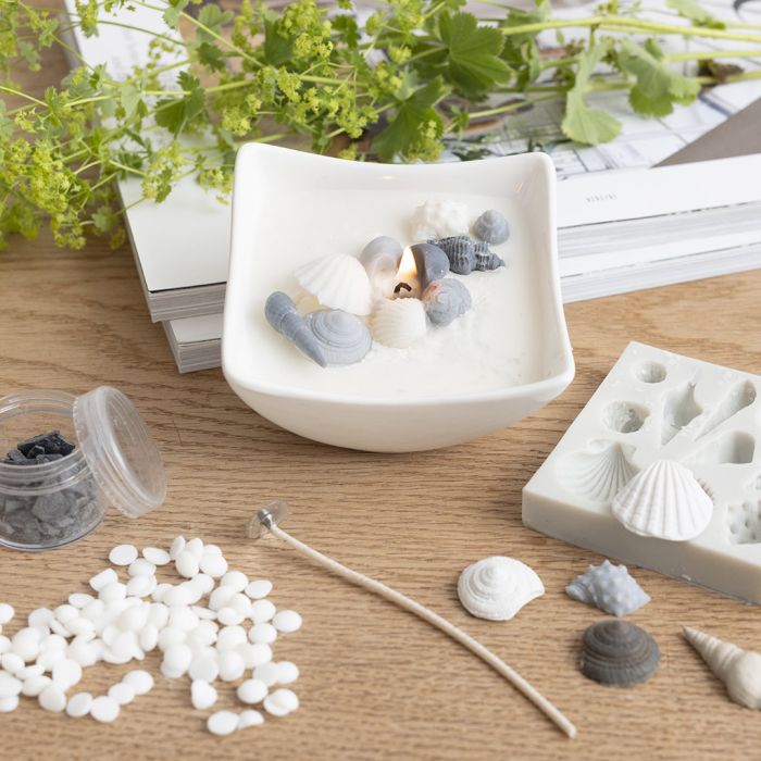 Kynttilä, jossa rantasimpukoita