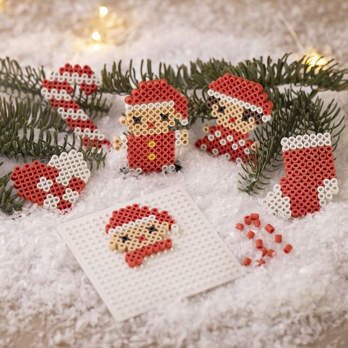Punottu joulutähti, karkkikeppi, tonttupoika, tonttutyttö ja joulusukka, kaikki valmistettu BioBeads-helmistä