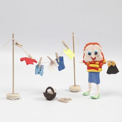 Hahmo Silk Clay:st&auml; ja puinen pyykkinaru, jossa on Silk Clay-vaatteita kuivumassa