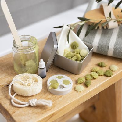 Matkapakkaus, jossa pieni&auml; oliivi&ouml;ljysaippuoita ja pesusieni