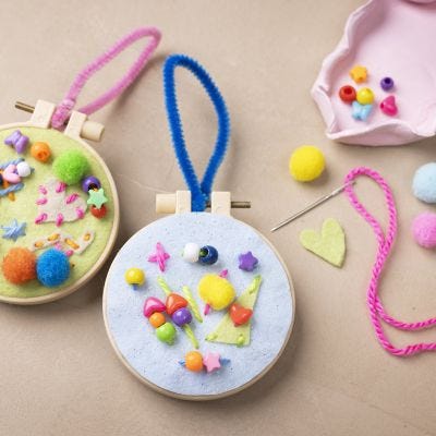 Kirjailtu ripustuskoriste mielikuvituksellisella koristelulla