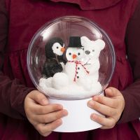 Läpinäkyvä pallo, jonka sisällä on lumiukko, pingviini ja jääkarhu.