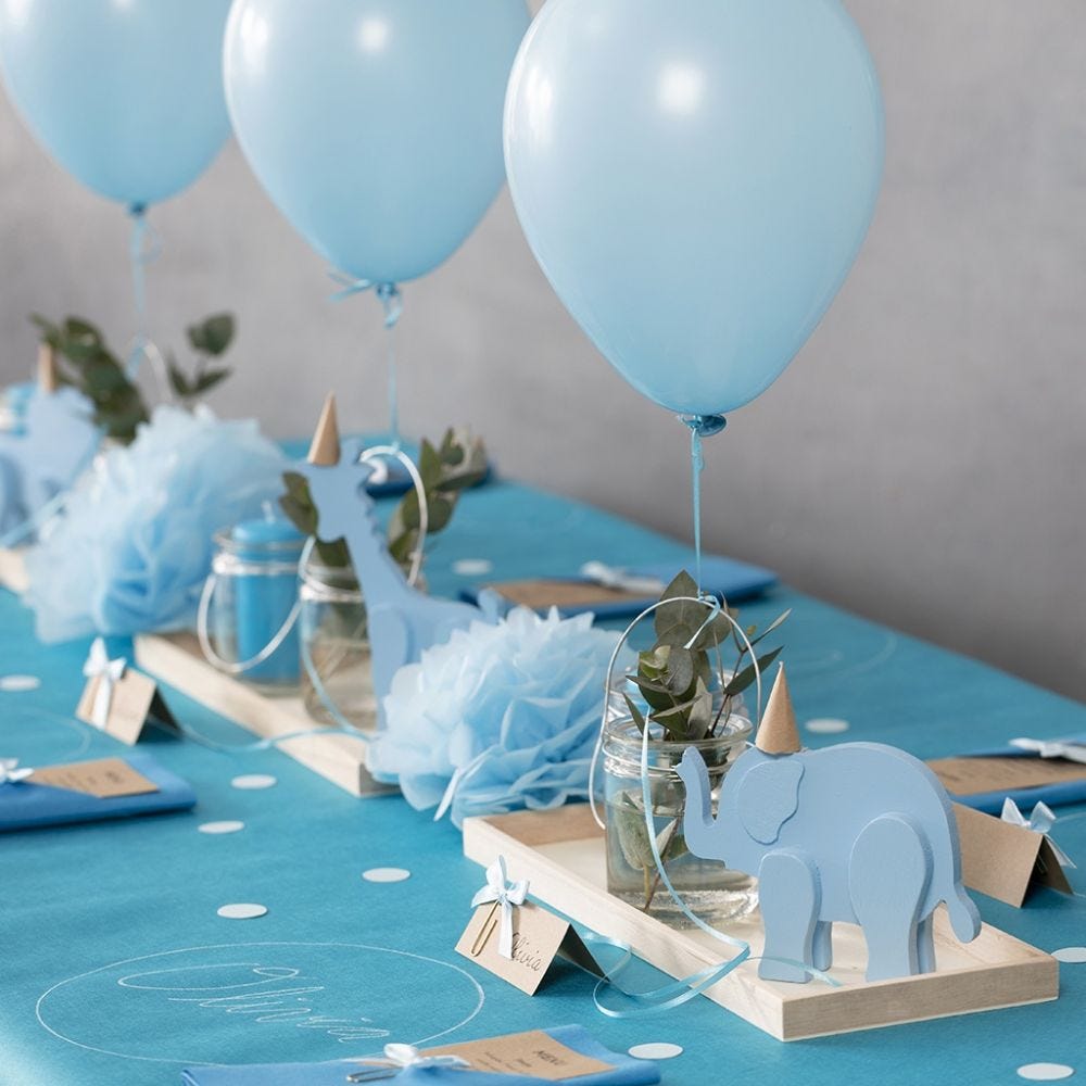 Ristiäiskoristeita puueläimistä, taitelluista servieteistä, menu-korteista, pom-pomeista ja helium-ilmapalloista.