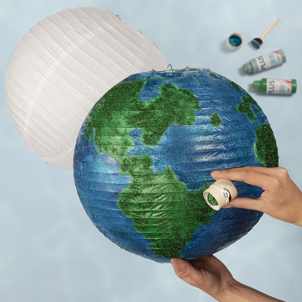 Maapallo paperilampusta, joka on koristeltu maalilla ja kimalteella
